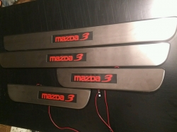 накладки на пороги с подсветкой Mazda3,светящиеся накладки на пороги Mazda 3,светодиодные накладки на пороги Mazda 3,светодиодные накладки на пороги авто Mazda 3,накладки на пороги Mazda 3,декоративные накладки Mazda 3