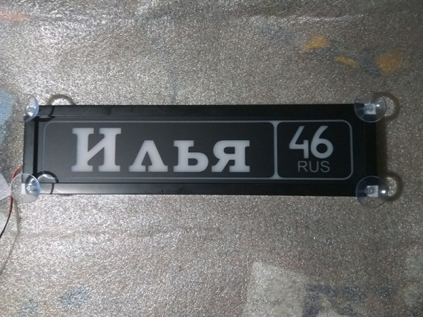 Именная светящаяся табличка на стекло Илья 46 RUS Табличка Илья 46 RUS  на стекло. Светящаяся табличка в стиле госномера с цифрами региона. Светящаяся табличка с именем водителя на стекло автомобиля, крепление на присоски, изготовление на заказ