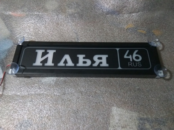 Именная светящаяся табличка на стекло Илья 46 RUS Табличка Илья 46 RUS  на стекло. Светящаяся табличка в стиле госномера с цифрами региона. Светящаяся табличка с именем водителя на стекло автомобиля, крепление на присоски, изготовление на заказ